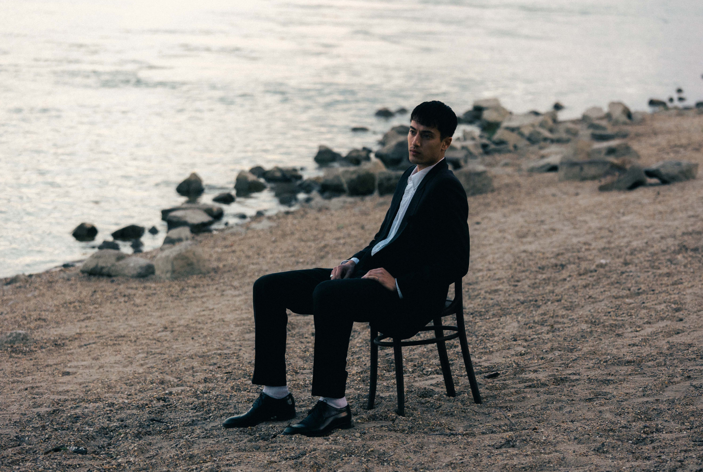 Artist Eden sitting on chair at beach